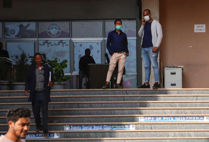 Des hommes portant des masques de protection se tiennent devant une cafétéria, après l’annonce du premier cas de Covid-19, à Addis-Abeba, le 13 mars 2020.